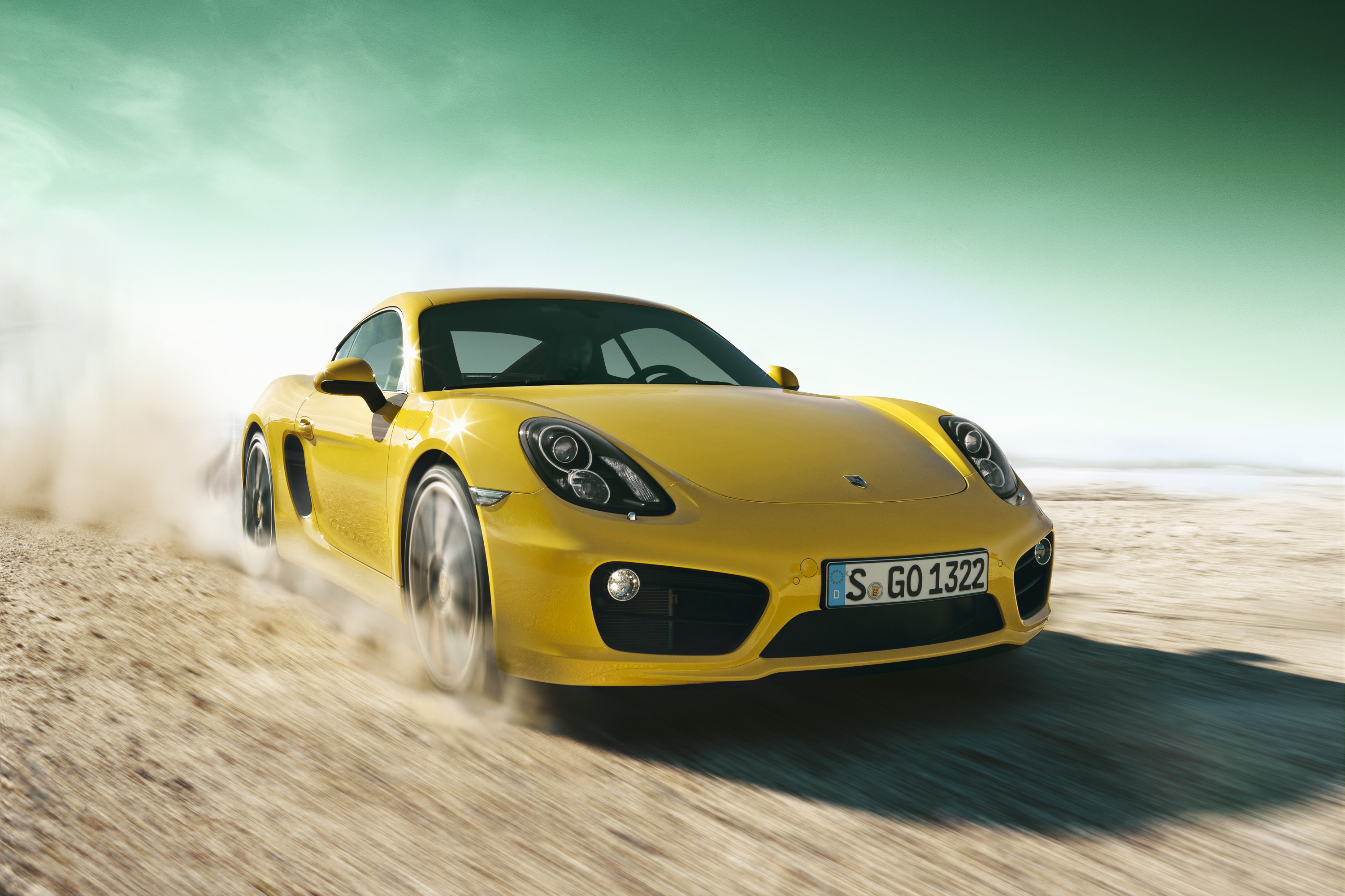 Porsche fährt schnell durch die Wüste und zieht eine Staubwolke nach sich