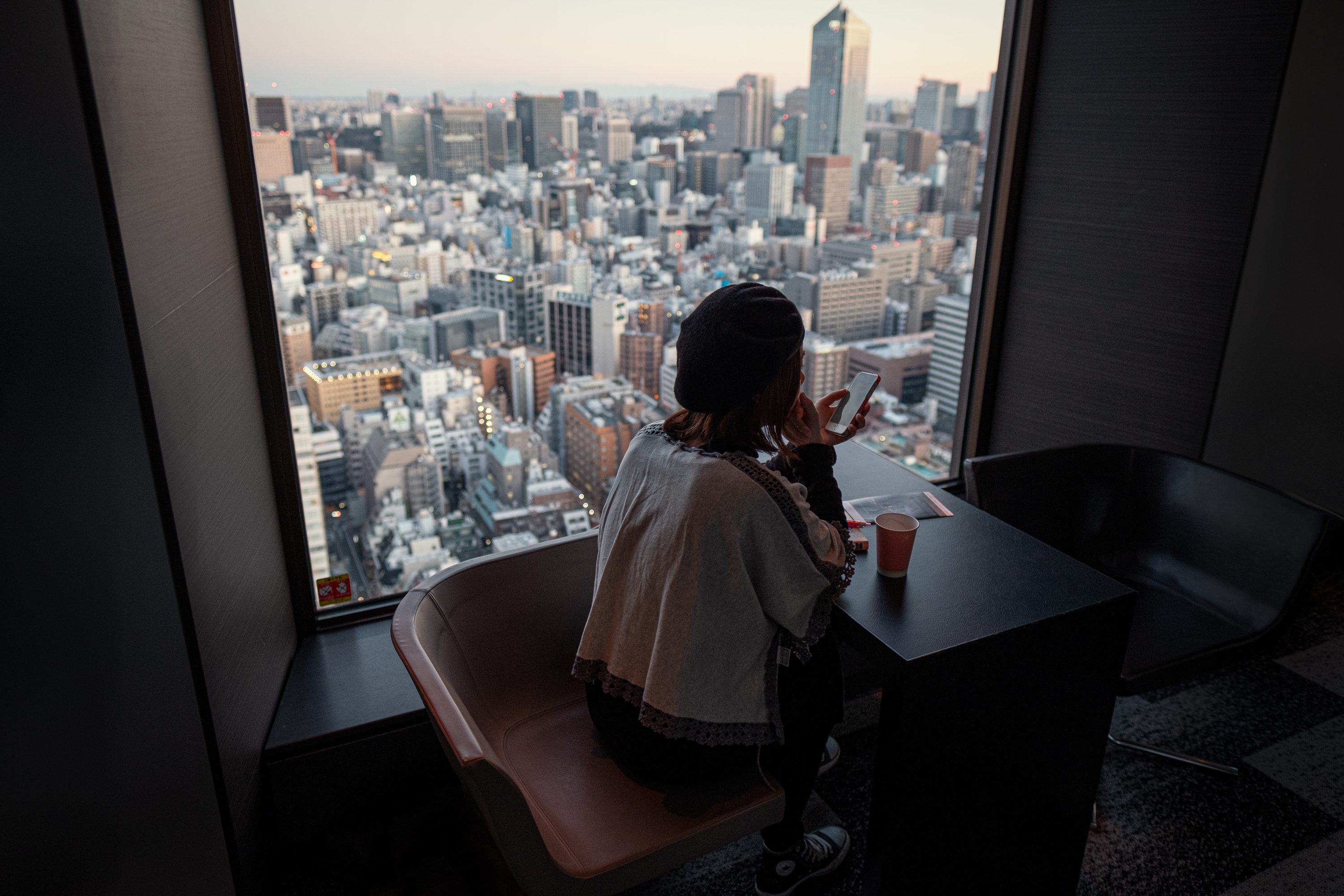 Frau schaut auf ihr Handy - Tokio von oben