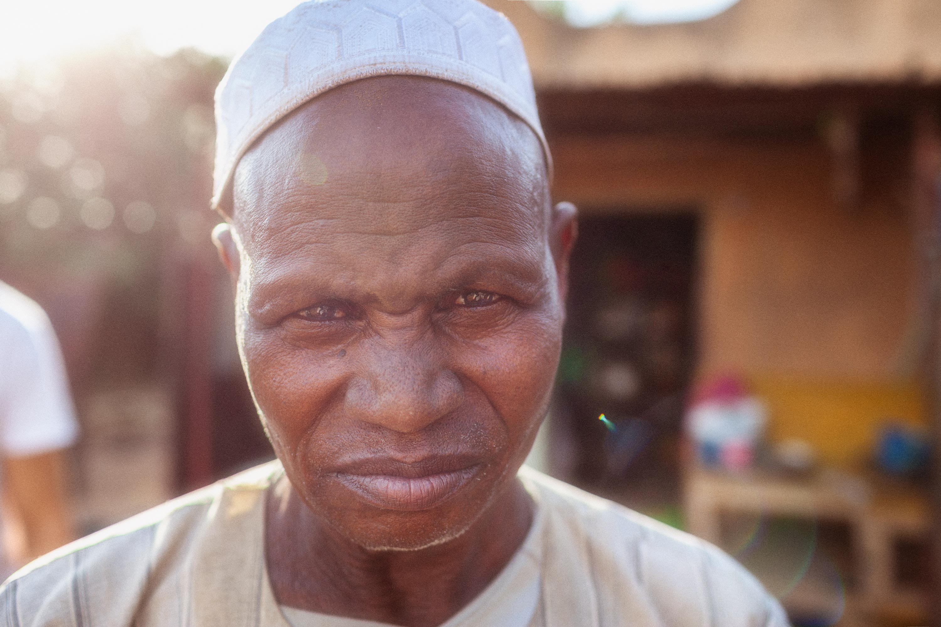 Mann vor einem Geschäft in Mali schaut böse in die Kamera