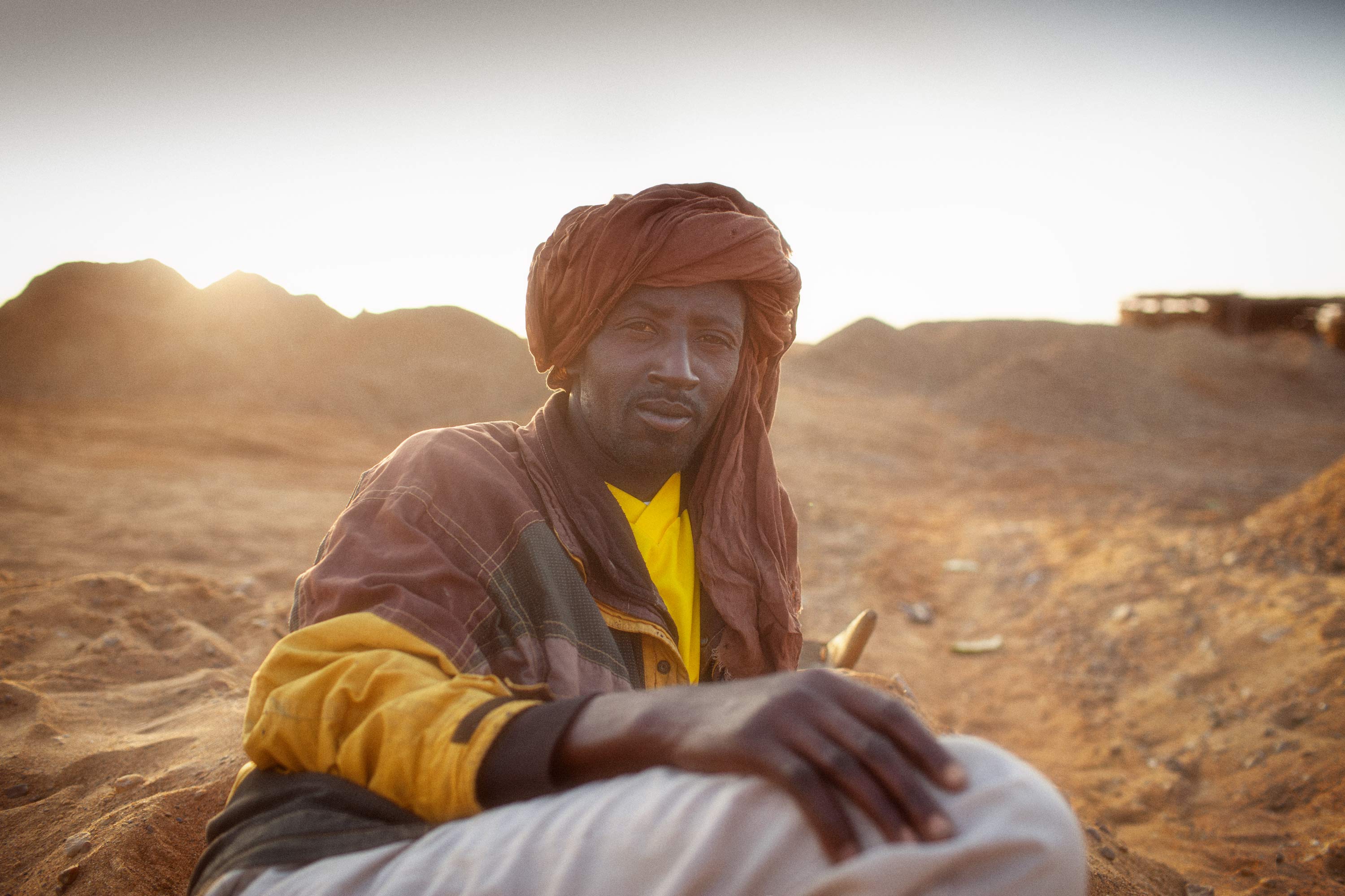 Mann mit Turban liegt im Sand Mali