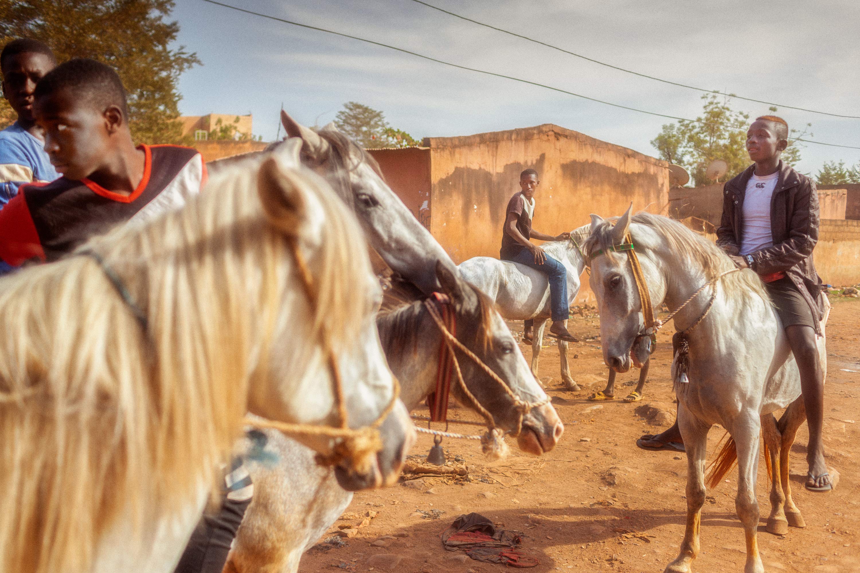 Junge Männer zu Pferd in einem Dorf in Mali